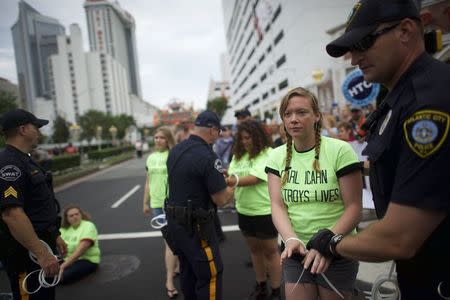 A woman is placed in hand cuffs, one of 70 union members arrested, for an act of civil disobedience in blocking traffic to the Trump Taj Mahal in Atlantic City, New Jersey on June 17, 2015. REUTERS/Mark Makela