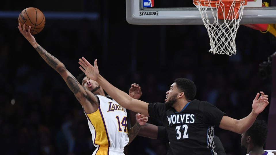 Los Angeles Lakers forward Brandon Ingram, left, and Minnesota Timberwolves center Karl-Anthony Towns reach for a rebound during the first half of an NBA basketball game, Sunday, April 9, 2017, in Los Angeles. (AP Photo/Mark J. Terrill)