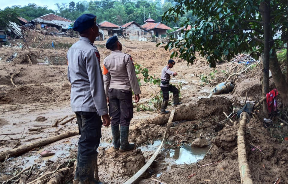 Rescuers search for victims at a village heavily affected by a landslide in Cigudeg, West Java, Indonesia, Friday, Jan. 3, 2020. Monsoon rains and rising rivers submerged hundreds of neighborhoods in greater Jakarta and caused landslides in the neighboring districts, which buried a number of people. (AP Photo/Kozer)