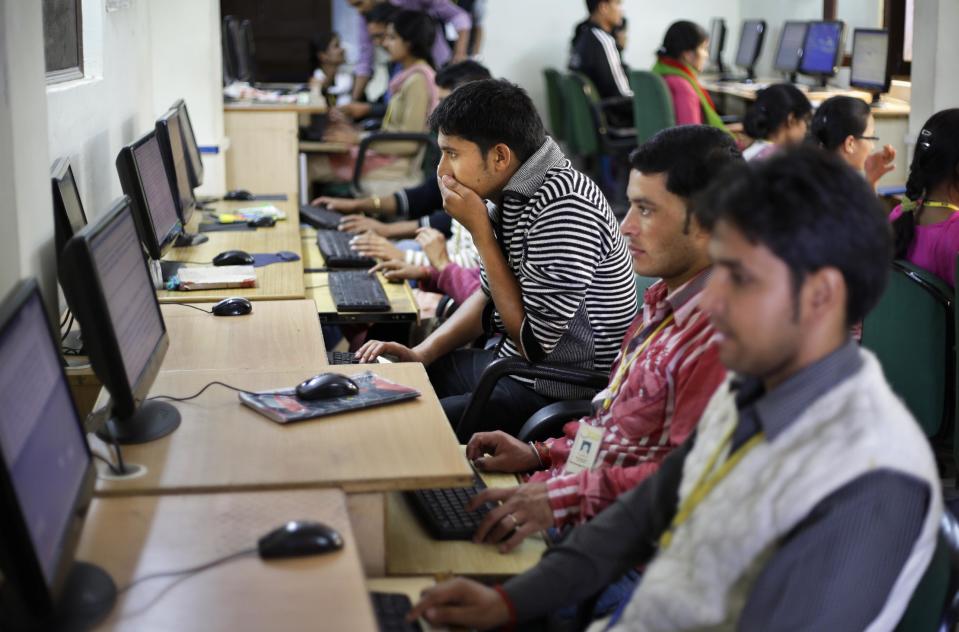 In this Aug. 23, 2012 photo, employees work on computers at the B2R center in Simayal, India. Before B2R arrived in Simayal, local women had little option but to marry right out of school, and educated young men had to travel far to seek respectable jobs. (AP Photo/Saurabh Das)