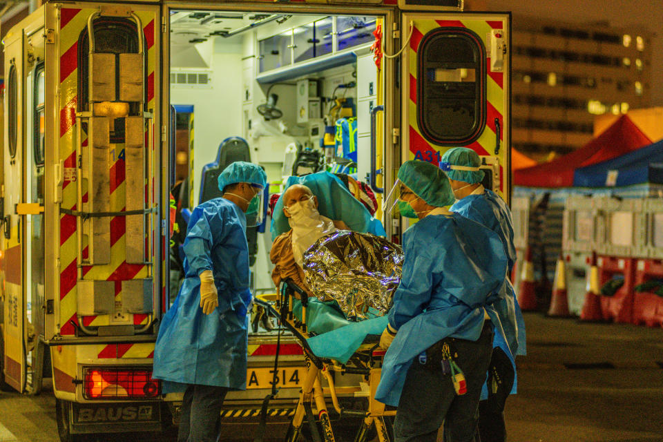 An elderly patient is transferred out of an ambulance by paramedics at Princess Margaret hospital, in Hong Kong, China, on March 16, 2022, in Hong Kong, China, on March 16, 2022.   (Photo by Marc Fernandes/NurPhoto via Getty Images)