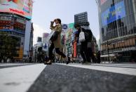 Less than usual pedestrians cross the Shibuya crossing after the government announced the state of emergency for the capital following the coronavirus disease outbreak in Tokyo, Japan