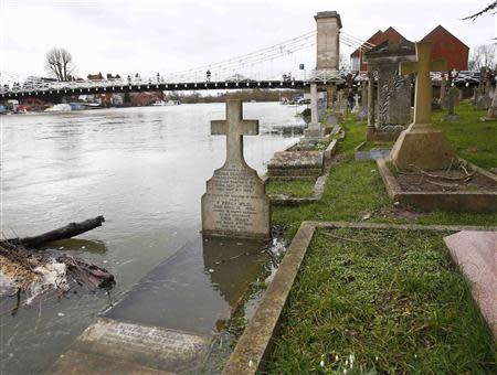 The river Thames floods into a graveyard at All Saints church in Marlow, southern England February 9, 2014. REUTERS/Eddie Keogh