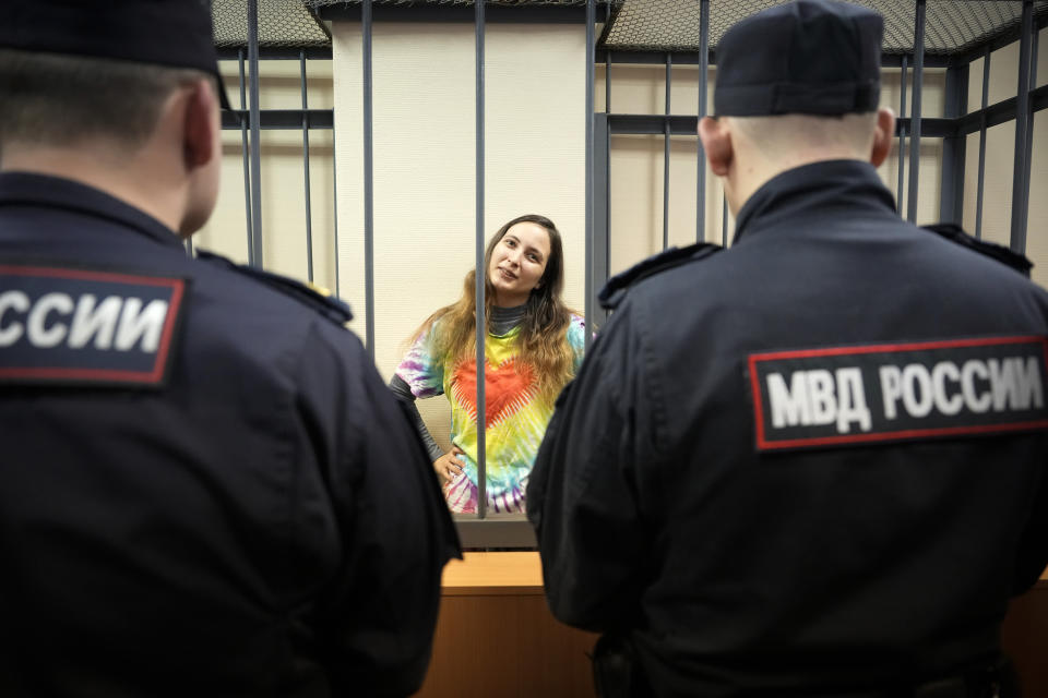 Sasha Skochilenko, a 33 year-old artist and musician stands behind bars in the court room before a hearing in the Vasileostrovsky district court in St. Petersburg, Russia, Thursday, Nov. 16, 2023. Skochilenko has been convicted of spreading false information about the military and sentenced to 7 years in prison after replacing several supermarket price tags with slogans criticizing Russia's military action in Ukraine. (AP Photo/Dmitri Lovetsky)