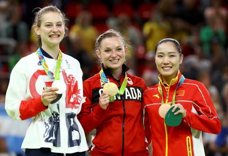 Gold medallist Rosannagh MacLennan (CAN) of Canada (C), silver medallist Bryony Page (GBR) of Britain (L) and bronze medallist Li Dan (CHN) of China pose with their medals after the women's trampoline final. REUTERS/Mike Blake