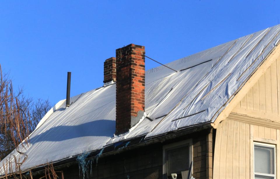 The roof of the building is covered with a plastic tarp.