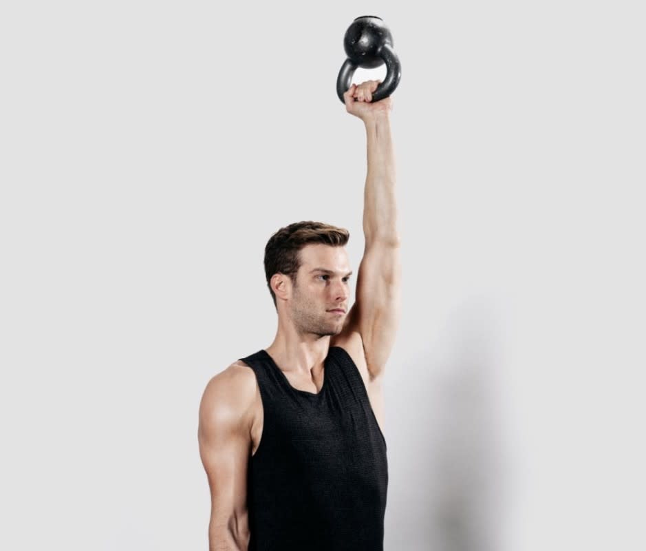 How to do it:<ul><li>Stand tall with feet shoulder-width apart, gripping a kettlebell in one hand at your shoulder.</li><li>Grasp the kettlebell’s handle, positioning the kettlebell upside down, so the bell is pointing toward the ceiling.</li><li>Keeping your wrist perfectly straight and the kettlebell steady, press your arm straight up, extending your elbow.</li><li>Carefully bend your elbow and lower the kettlebell back to shoulder height.</li></ul>