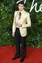 <p>in a gold Gucci blazer and necktie shirt, plus a Cartier watch. </p>