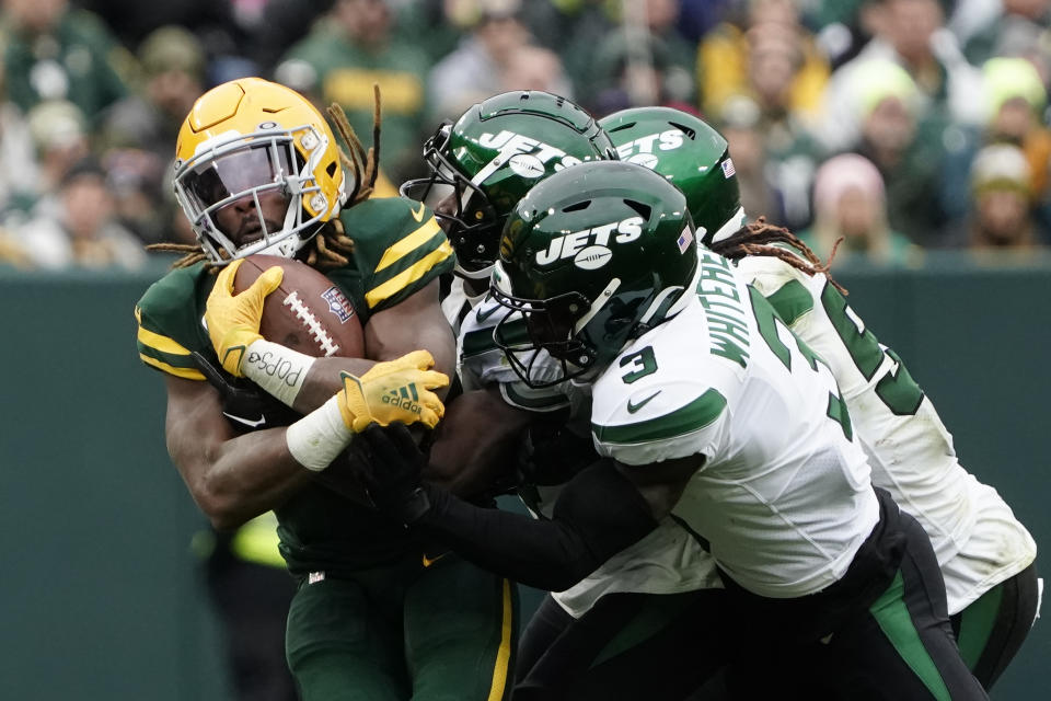 Green Bay Packers running back Aaron Jones, left, is stopped during the second half of an NFL football game against the New York Jets, Sunday, Oct. 16, 2022, in Green Bay, Wis. (AP Photo/Morry Gash)