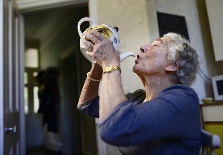 British children's writer and illustrator Judith Kerr drinks from a tea pot as she recreates a scene from her bestselling picture book "The Tiger Who Came To Tea", at her home in west London, Britain September 30, 2015. REUTERS/Dylan Martinez