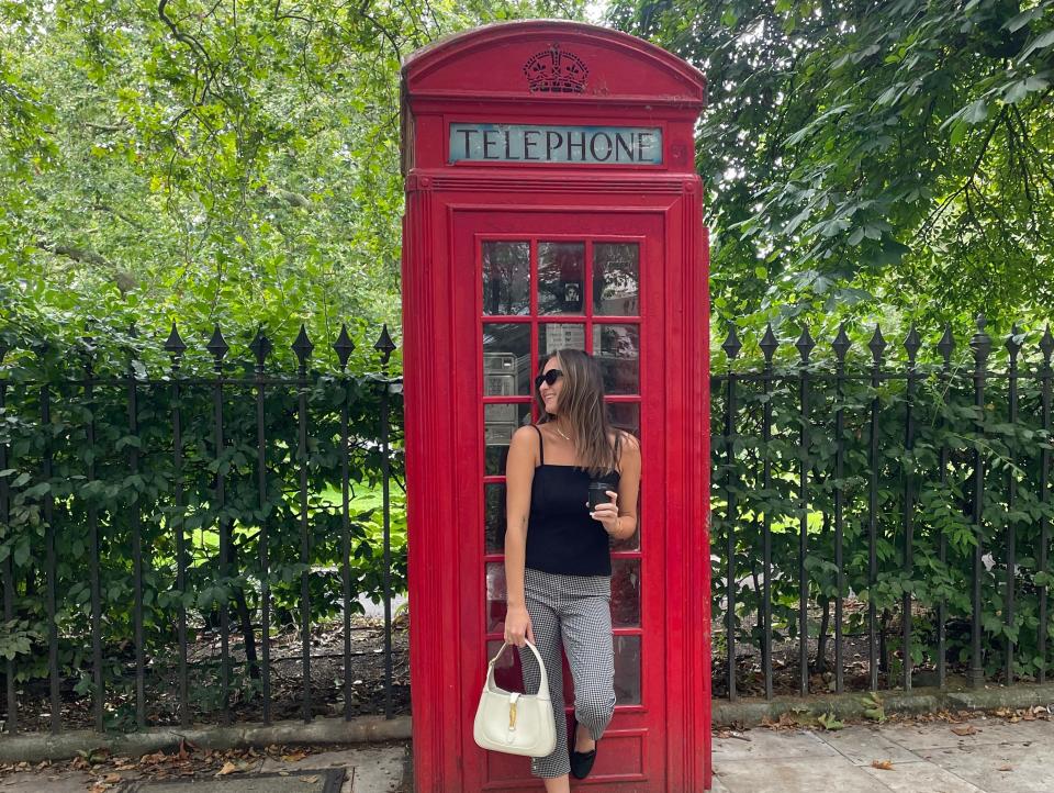 Kelly posing in front of a red telephone box in London