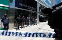 Police officers stand guard outside the building where Dr. Luque has his office in Buenos Aires