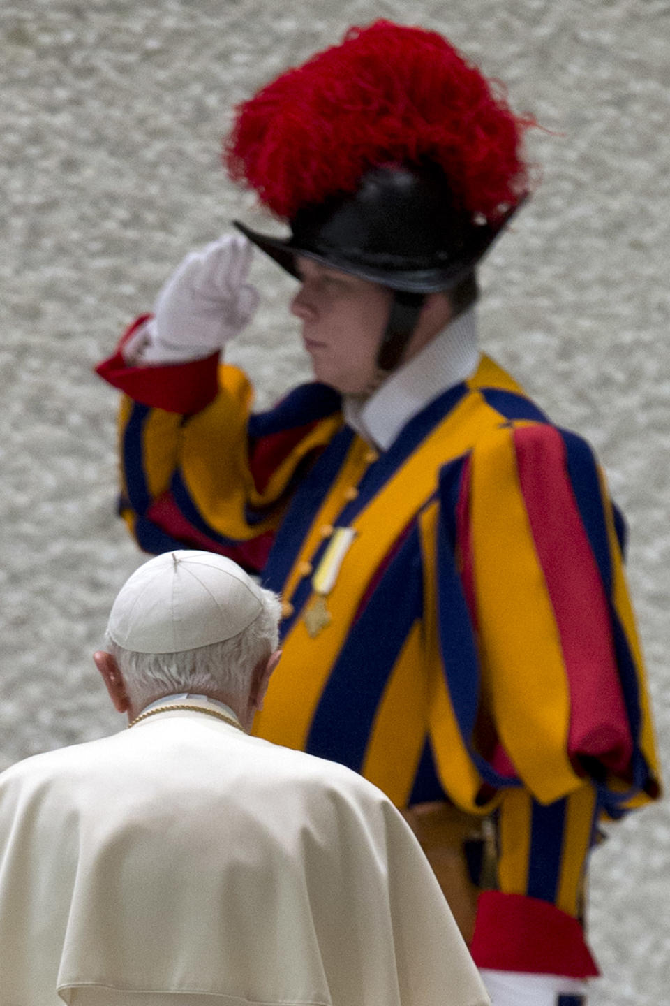 A Swiss Guard salutes as Pope Benedict XVI leaves at the end of his weekly general audience in the Paul IV hall at the Vatican, Wednesday, Jan. 2, 2013. (AP Photo/Andrew Medichini)