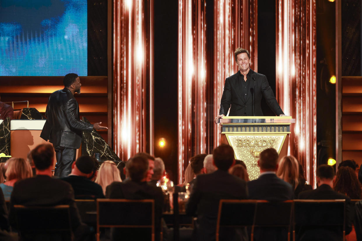 Kevin Hart and Tom Brady speak onstage during The Greatest Roast Of All Time: Tom Brady for the Netflix is a Joke Festival at The Kia Forum on May 05, 2024 in Inglewood, California.  / Credit: Matt Winkelmeyer/Getty Images for Netflix