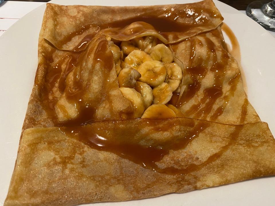 Banana crepe with caremel on white plate at le creperie de paris at epcot