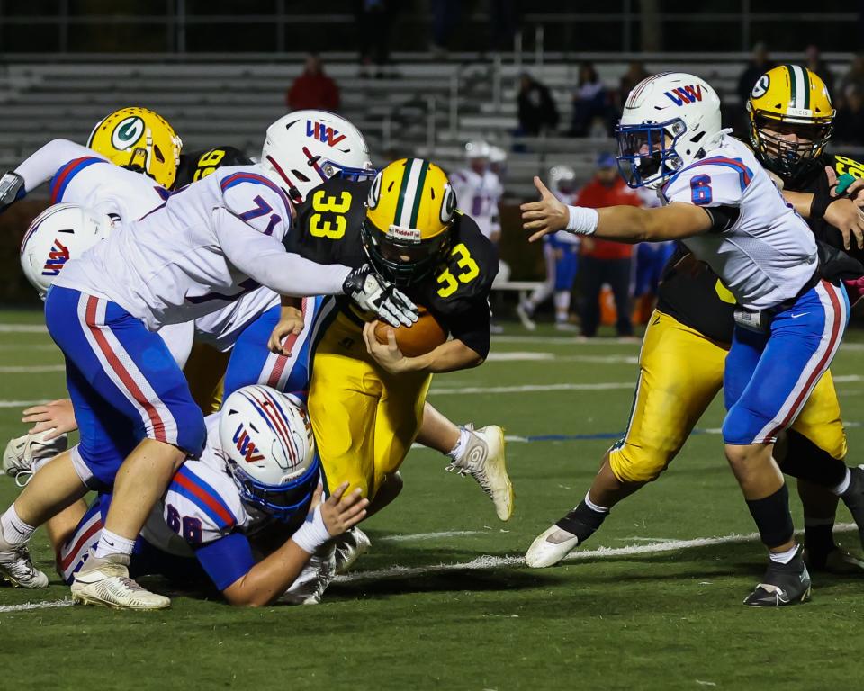 Winnacunnet's Jack Hogan (71) and Jake Fredericks (66) bring down Bishop Guertin's Ethan Labbe as Brooks Connors comes to assist during a Division I football game this season at Stellos Stadium in Nashua.