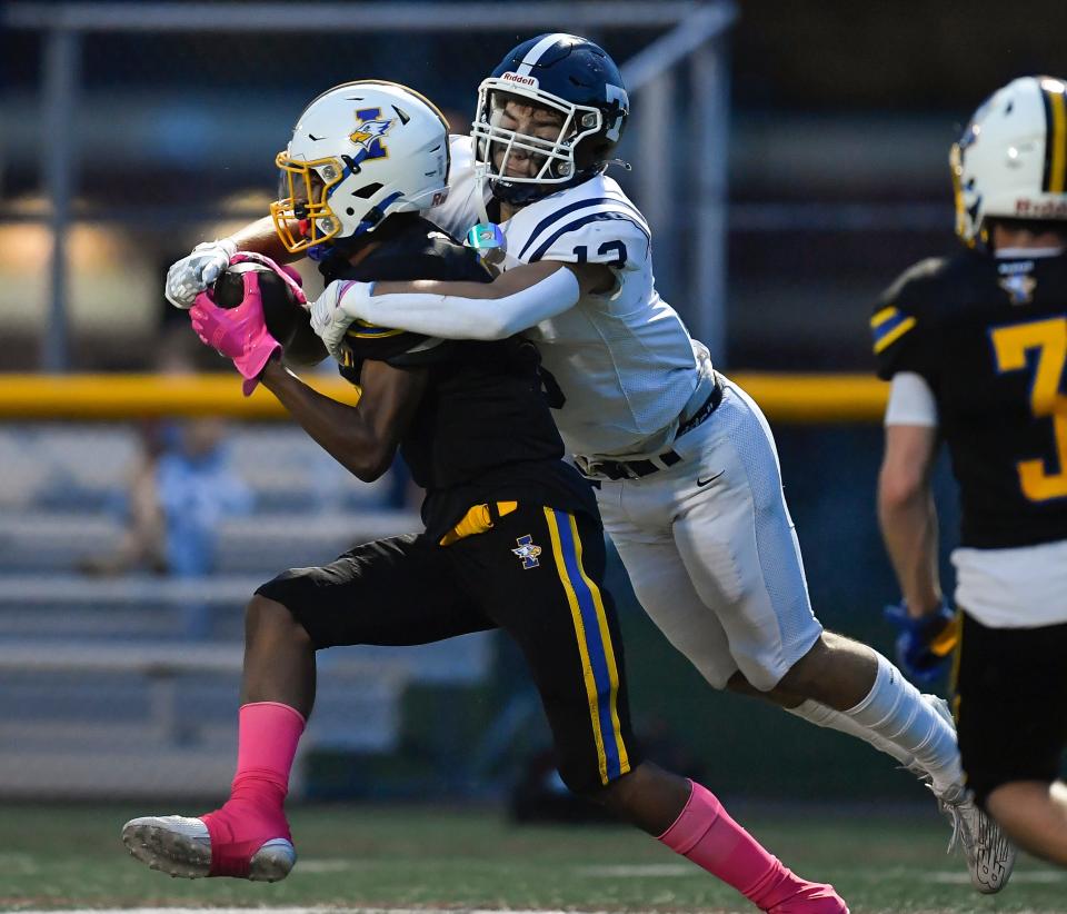 Irondequoit's Cristian Freeman, left, intercepts a pass intended for Webster Thomas' Joseph Baller during a regular season game, Thursday, Oct. 5, 2023.