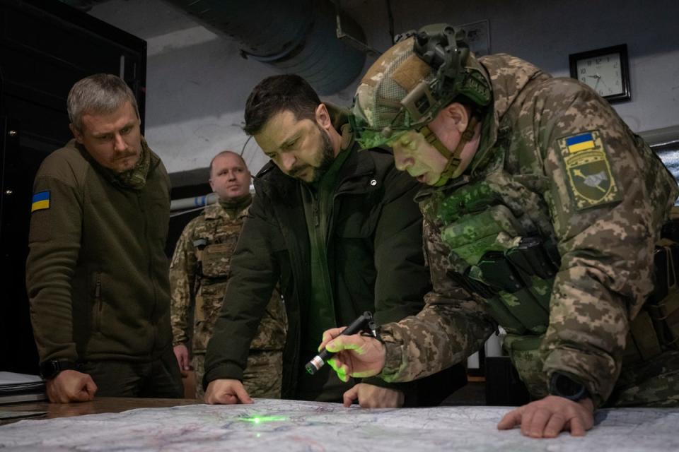 Ukrainian President Volodymyr Zelensky, Commander of Ukraine's Ground Forces Col.-Gen. Oleksandr Syrsky, right, and Roman Mashovets, deputy head of the Presidential Office, look at a map during their visit to the front-line city of Kupiansk (AP)