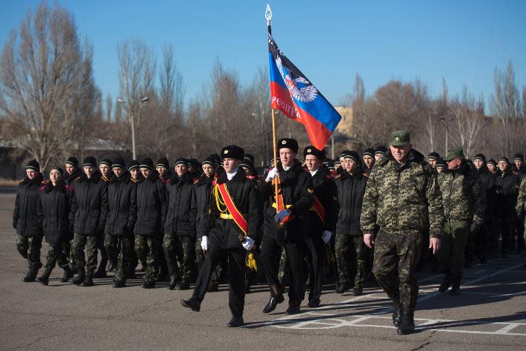 Young military school cadets march with the flag of the self-proclaimed Donetsk People's Republic during a swearing-in ceremony on November 22, 2014