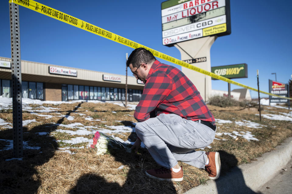 Jace Khosla places flowers early Sunday, Nov. 20, 2022, near police tape surrounding Club Q, a gay bar in Colorado Springs, Colo., where a mass shooting took place late on Saturday. Khosla is from Pueblo, Colo., and said many of his friends frequent the bar and he's still waiting to hear if anyone he knows was a victim. "I'm waiting for my phone to go off," he said. (Parker Seibold/The Gazette via AP)