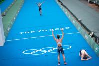 <p>Winner Bermuda's Flora Duffy (C), third-placed USA's Katie Zaferes (top L) and second-placed Britain's Georgia Taylor-Brown (R) react after completing the women's individual triathlon competition during the Tokyo 2020 Olympic Games at the Odaiba Marine Park in Tokyo on July 27, 2021. (Photo by Loic VENANCE / AFP)</p> 