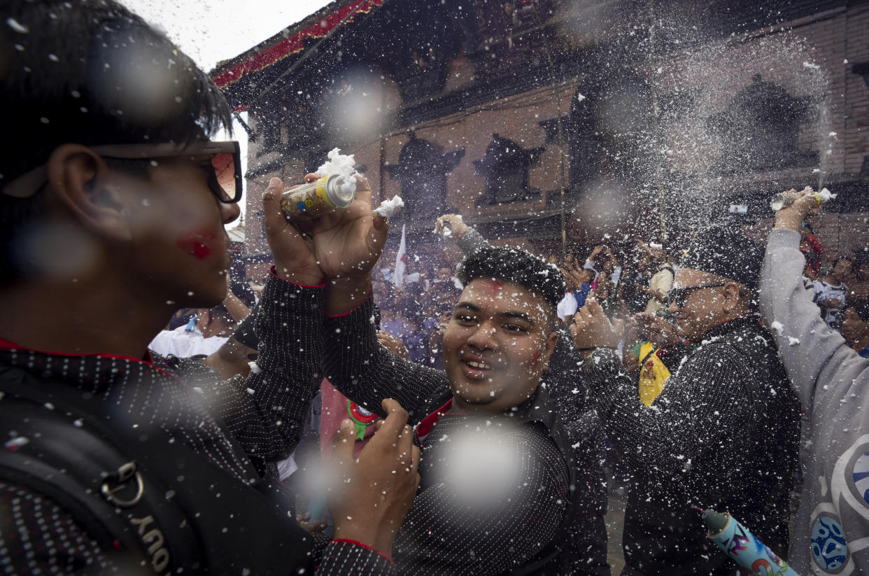 Devotees use foam spray as they dance during Indra Jatra, a festival that marks the end of the rainy season in Kathmandu, Nepal, Tuesday, Sept. 17, 2024. (AP Photo/Niranjan Shrestha)