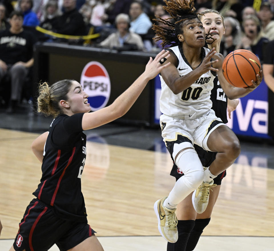 Colorado guard Jaylyn Sherrod (00) drives to the basket against Stanford defenders in the second half of an NCAA college basketball game Sunday, Jan, 14, 2024, in Boulder, Colo. (AP Photo/Cliff Grassmick)