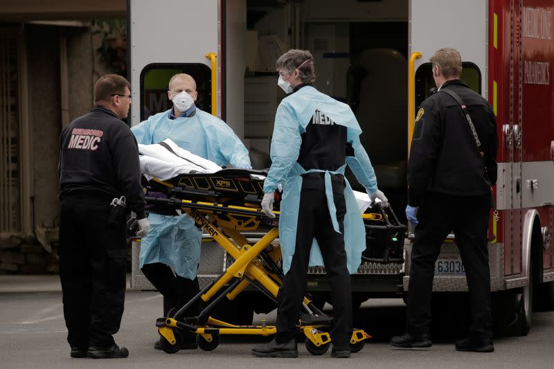 Medics prepare to transfer a patient on a stretcher to an ambulance at the Life Care Center of Kirkland, the long-term care facility linked to the two of three confirmed coronavirus cases in the state, in Kirkland