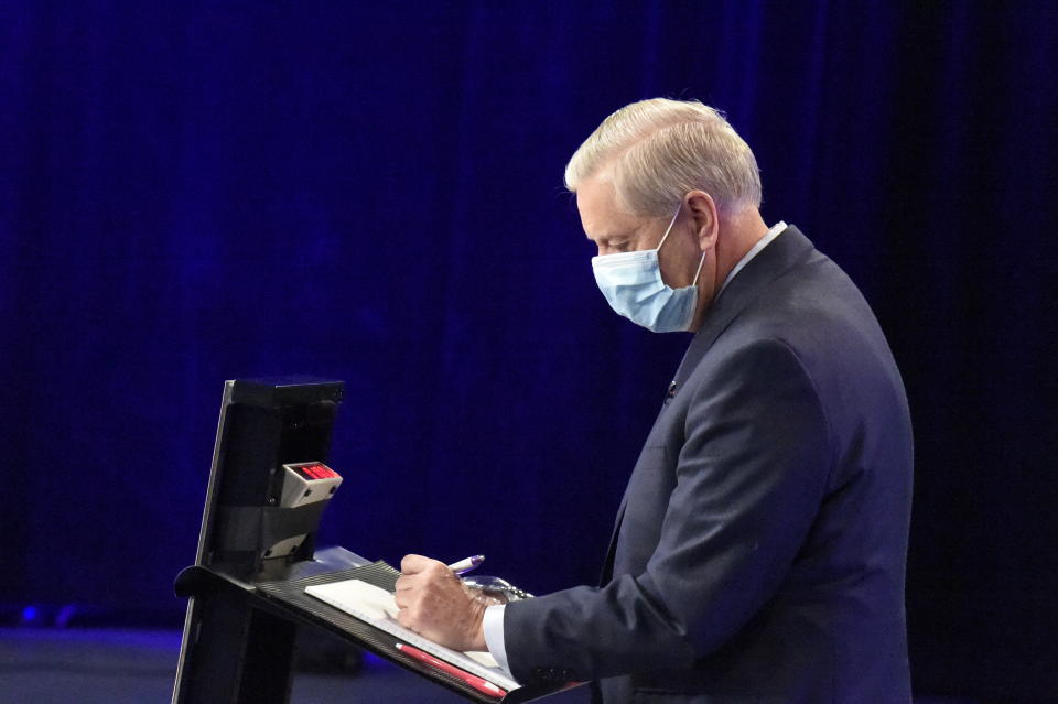 U.S. Sen. Lindsey Graham of South Carolina makes notes before a debate with Democratic challenger Jaime Harrison on Friday, Oct. 30, 2020, in Columbia, S.C. (AP Photo/Meg Kinnard)