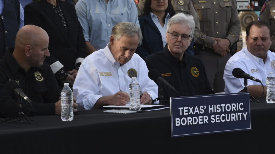 Texas Gov. Greg Abbott signs three bills into law last week at a border wall construction site in Brownsville, Texas. They included a controversial measure that makes entering Texas illegally a state crime and gives local law enforcement the power to arrest migrants. - Valerie Gonzalez/AP