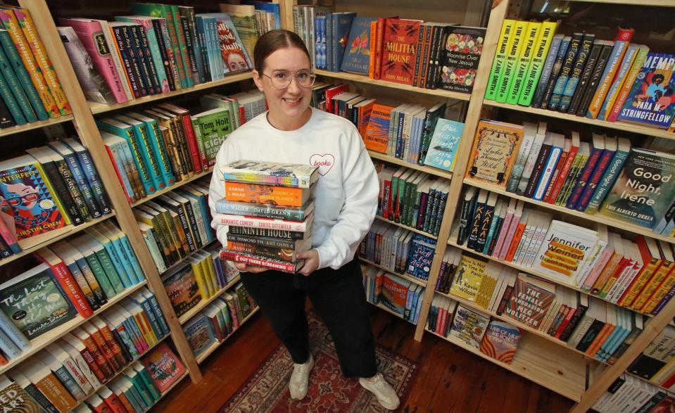 Owner Alison Sheridan holds some of her favorite books inside Cleary's Bookstore on North Main Street in Mount Holly early Tuesday morning, Dec. 12, 2023.