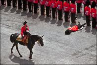 <p>A soldier passes out as the Queen rides by during the Trooping the Colour parade.</p>