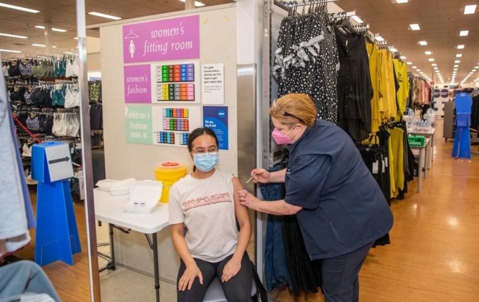 A woman receives a vaccine at a Big W vaccination centre. Source: Woolworths Group