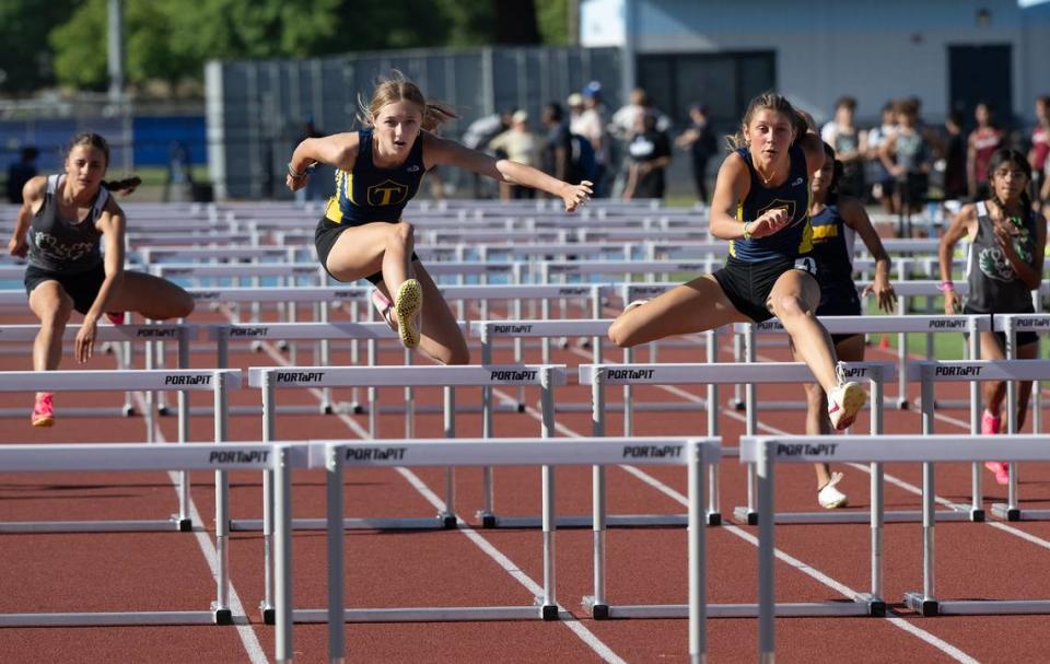 Turlock’s Cali Brem, right, edged out teammate Evelyn Ladine, left, to win the girls 100 meter hurdles with a time of 15.27 in the Central California Athletic League Championships at Downey High School in Modesto, Calif., Wednesday, May 1, 2024.