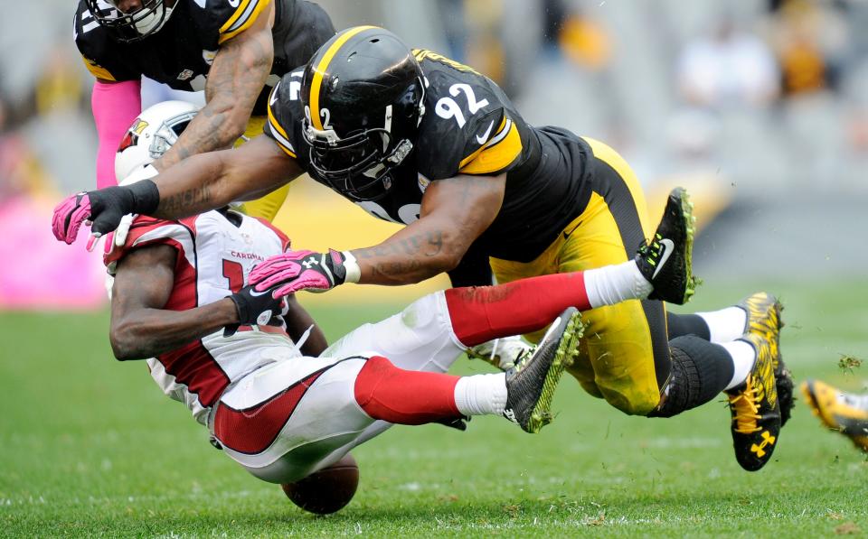 Arizona Cardinals wide receiver John Brown (12) fumbles after being hit by Pittsburgh Steelers outside linebacker James Harrison (92) on Oct. 18, 2015, in Pittsburgh.