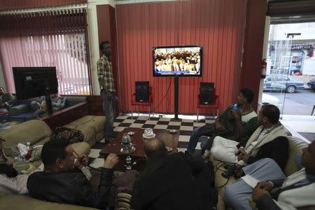 People watch television as an announcement by the Houthi movement on dissolving the parliament is made in Sanaa February 6, 2015. REUTERS/Mohamed al-Sayaghi