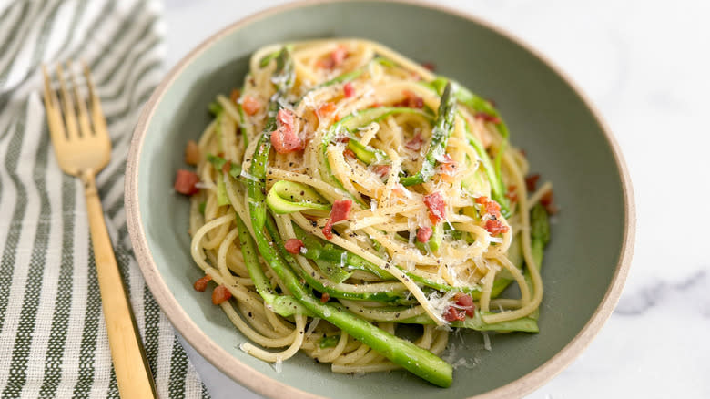 spaghetti carbonara with asparagus in bowl
