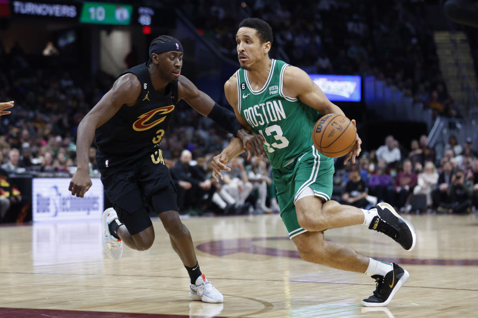 Boston Celtics guard Malcolm Brogdon drives against Cleveland Cavaliers guard Caris LeVert (3) during the second half of an NBA basketball game, Monday, March 6, 2023, in Cleveland. (AP Photo/Ron Schwane)