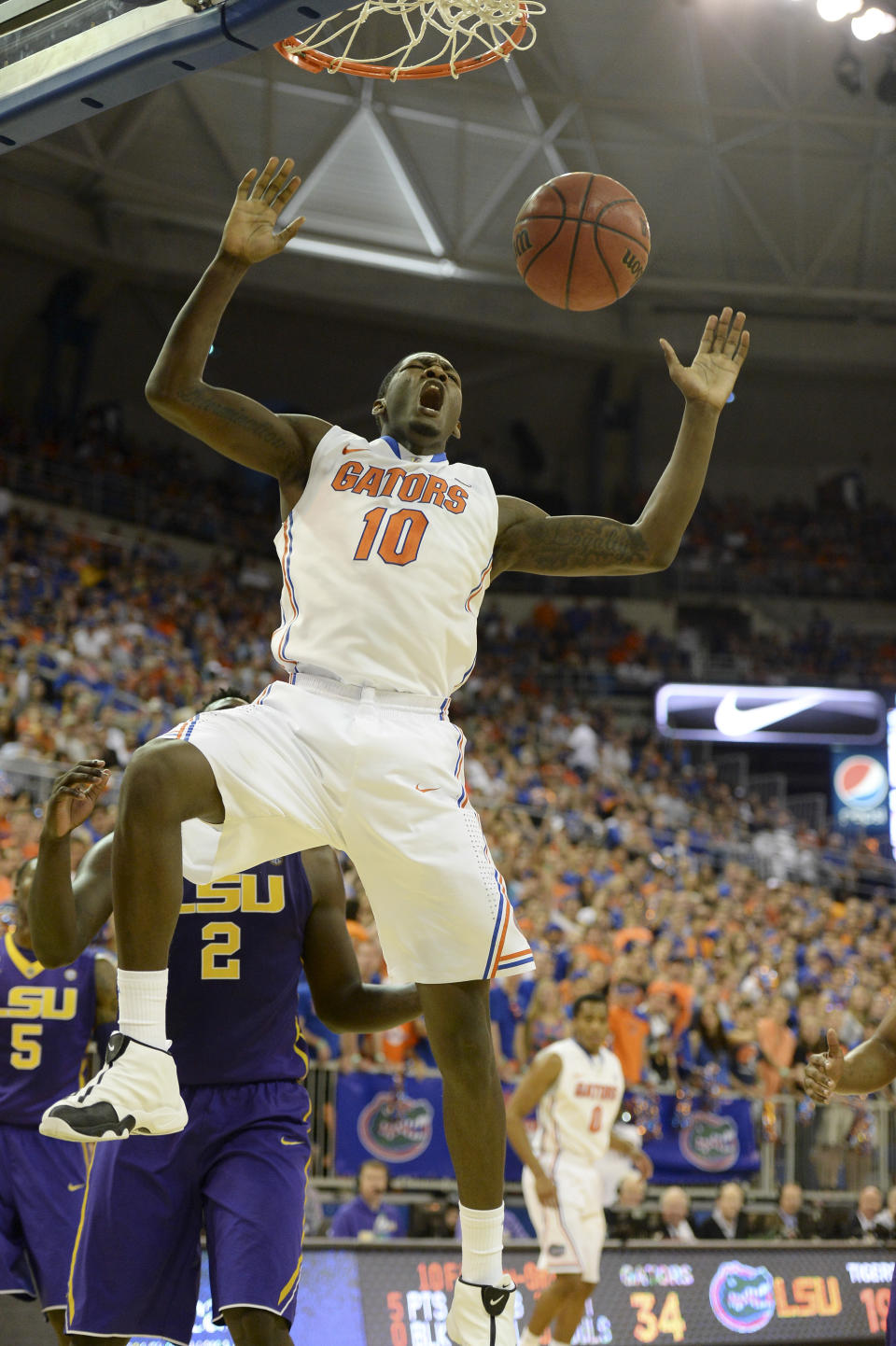 Florida forward Dorian Finney-Smith (10) jams the ball through the basket as LSU forward Johnny O'Bryant III (2) stands nearby during the first half of an NCAA college basketball game on Saturday, March 1, 2014, in Gainesville, Fla. (AP Photo/Phil Sandlin)