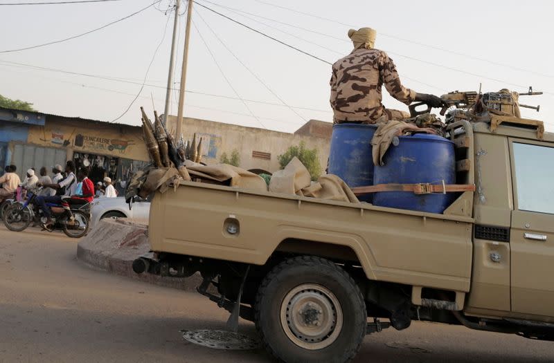 Members of the security forces drive along the market following the battlefield death of President Idriss Deby in N'Djamena