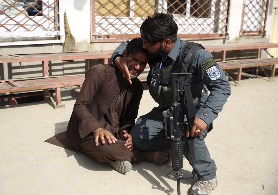 Afghan policeman comforts a man after an attack on a maternity hospital, in Kabul, Afghanistan, Tuesday, May 12, 2020. Militants stormed a maternity hospital in the western part of Kabul on Tuesday, setting off an hours-long shootout with the police and killing over a dozen people, including two newborn babies, their mothers and an unspecified number of nurses (AP Photo/Rahmat Gul)