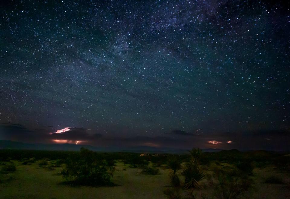 Bolts of lightning illuminate the desert floor at Joshua Tree National Park.