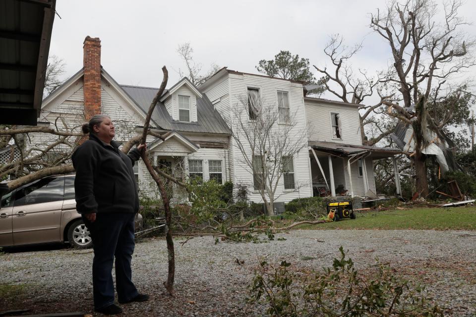 Tammy Esther, daughter of Ellen White, stands outside her mother's home and surveys the damage caused by a tornado that hit Cairo, Ga. Sunday night March 3, 2019.