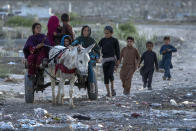 Afghan children return home from work in one of Kabul's poor neighbourhoods in Kabul, Afghanistan, Friday, May 20, 2022. Some 1.1 million Afghan children under the age of five will face malnutrition by the end of the year. , as hospitals wards are already packed with sick children . (AP Photo/Ebrahim Noroozi)