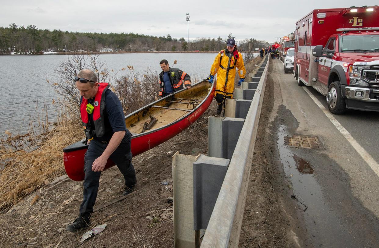 Leominster firefighters carry a canoe that was spotted capsized Thursday near the middle of Notown Reservoir.