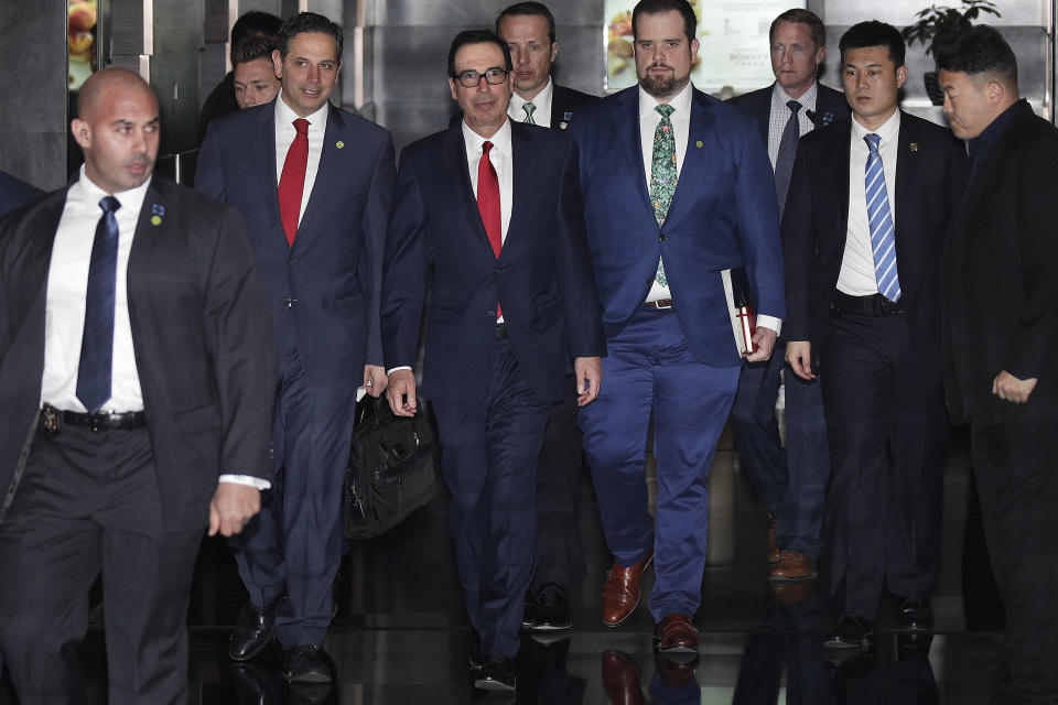 U.S. Treasury Secretary Steven Mnuchin, third from left, is escorted by bodyguards and a delegation leaves a hotel in Beijing, Friday, March 29, 2019. U.S. trade negotiators lead by Mnuchin and Trade Representative Robert Lighthizer arrived in Beijing to start a new round of talks aimed at ending a tariff war over China's technology ambitions as officials hint they might be making progress. (AP Photo/Andy Wong)