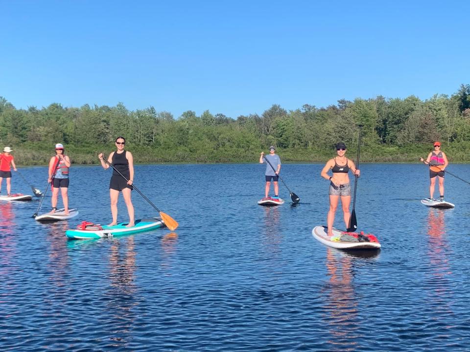 Participants stand during a paddle boat tour in Holland. Owner Beth Felicelli recently launched Tulip City Paddle Tours, providing a way to explore the area from a different angle.