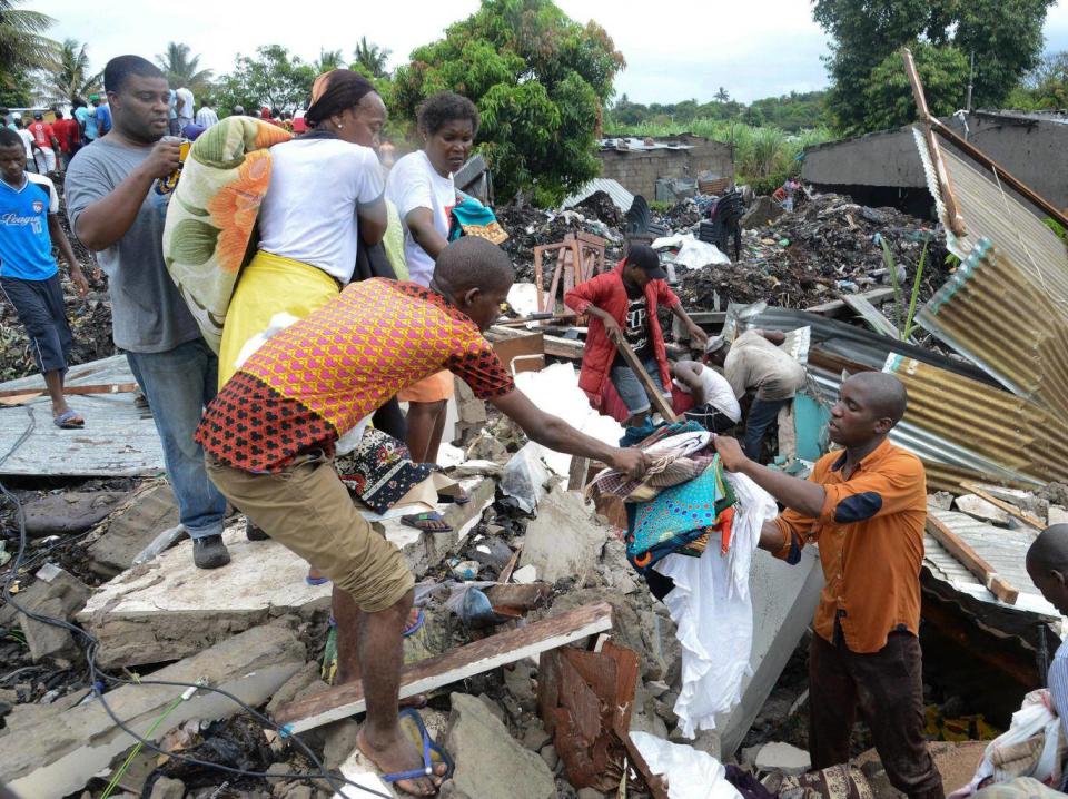 People look for their belongings under collapsed garbage piles in Maputo (EPA)