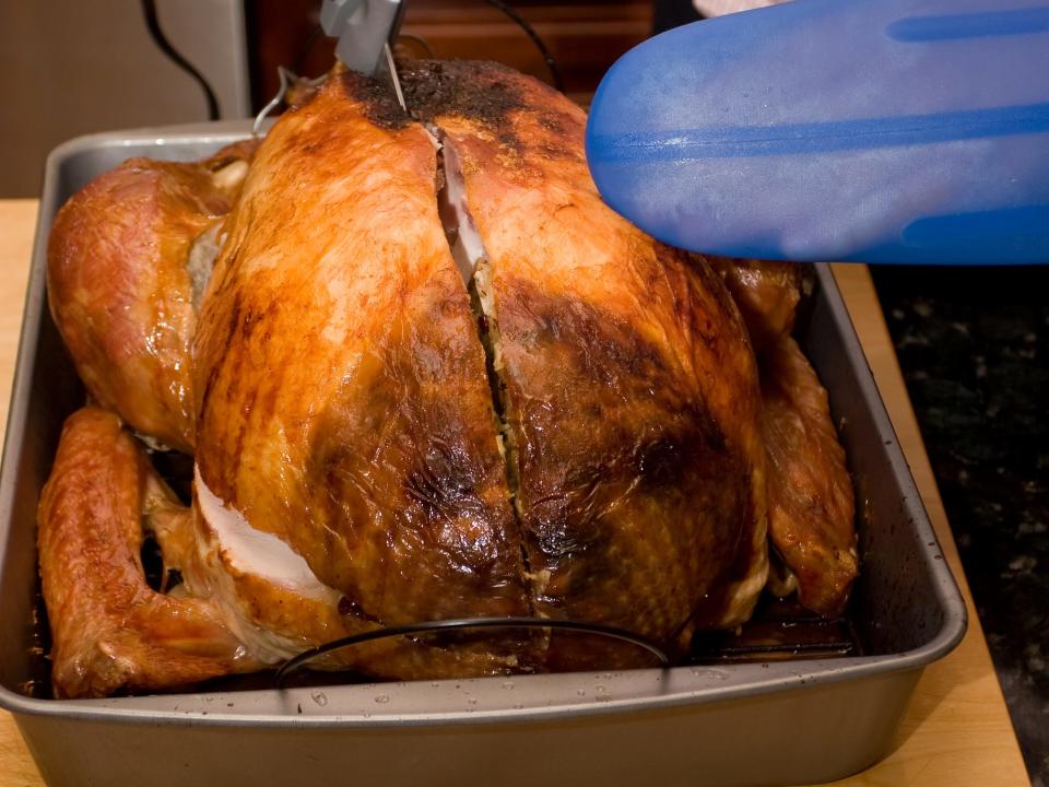 A person cutting a turkey into sections