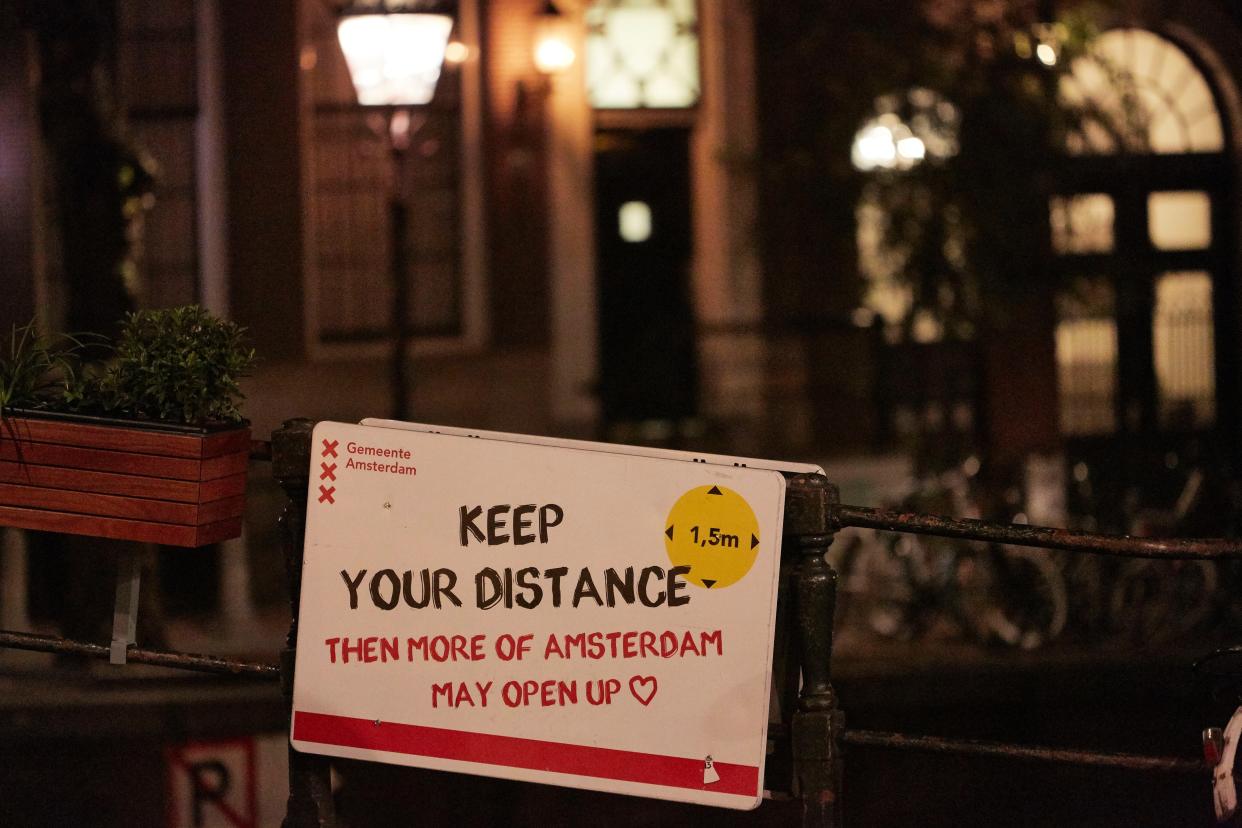 A board reads "Keep Your Distance 1,5 m Then More Of Amsterdam Open Up" on Sept. 21, 2020 in Amsterdam, Netherlands.